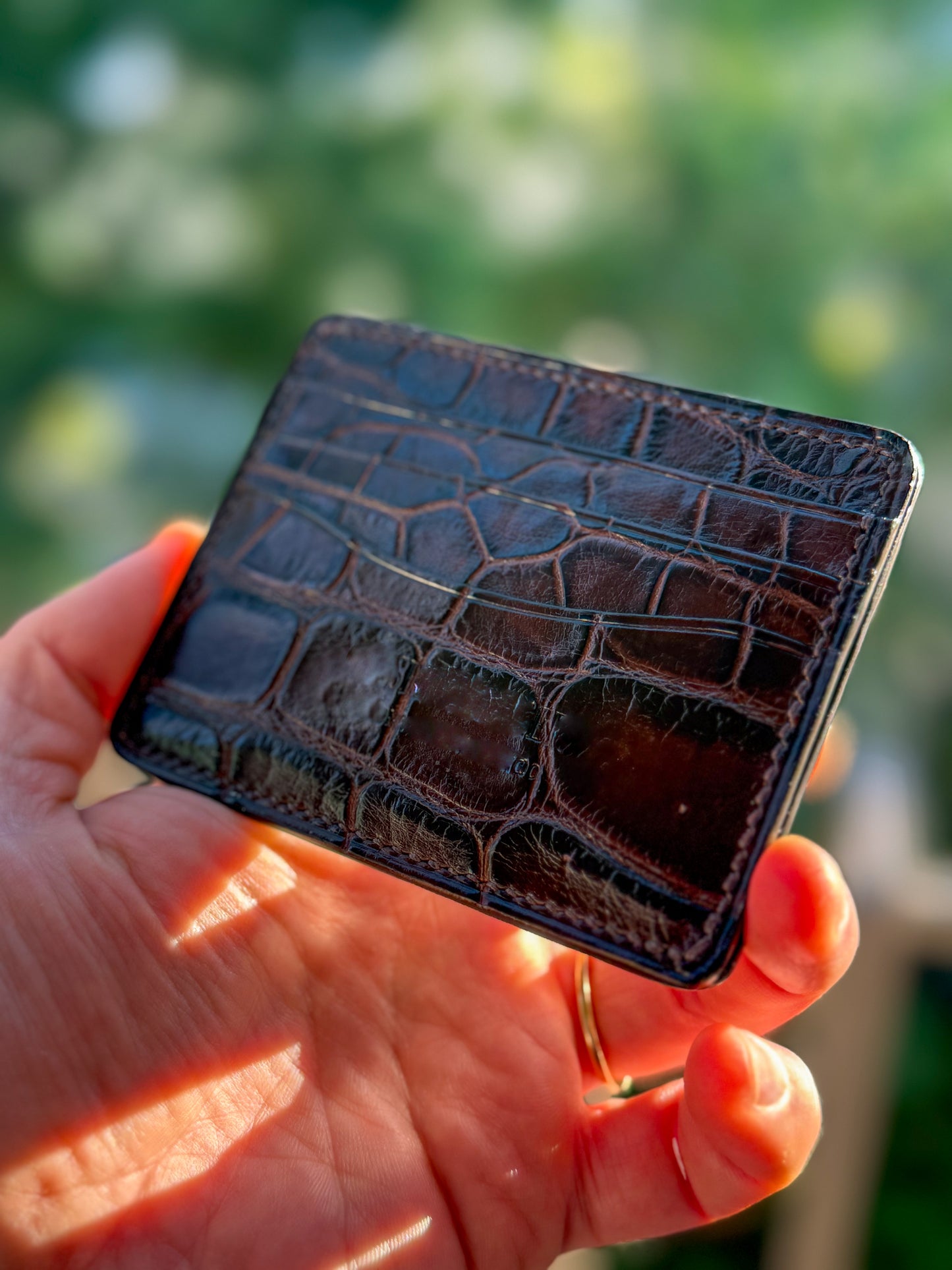 
                  
                    Close-up of dark brown alligator leather highlighting natural scale texture, precise stitching
                  
                