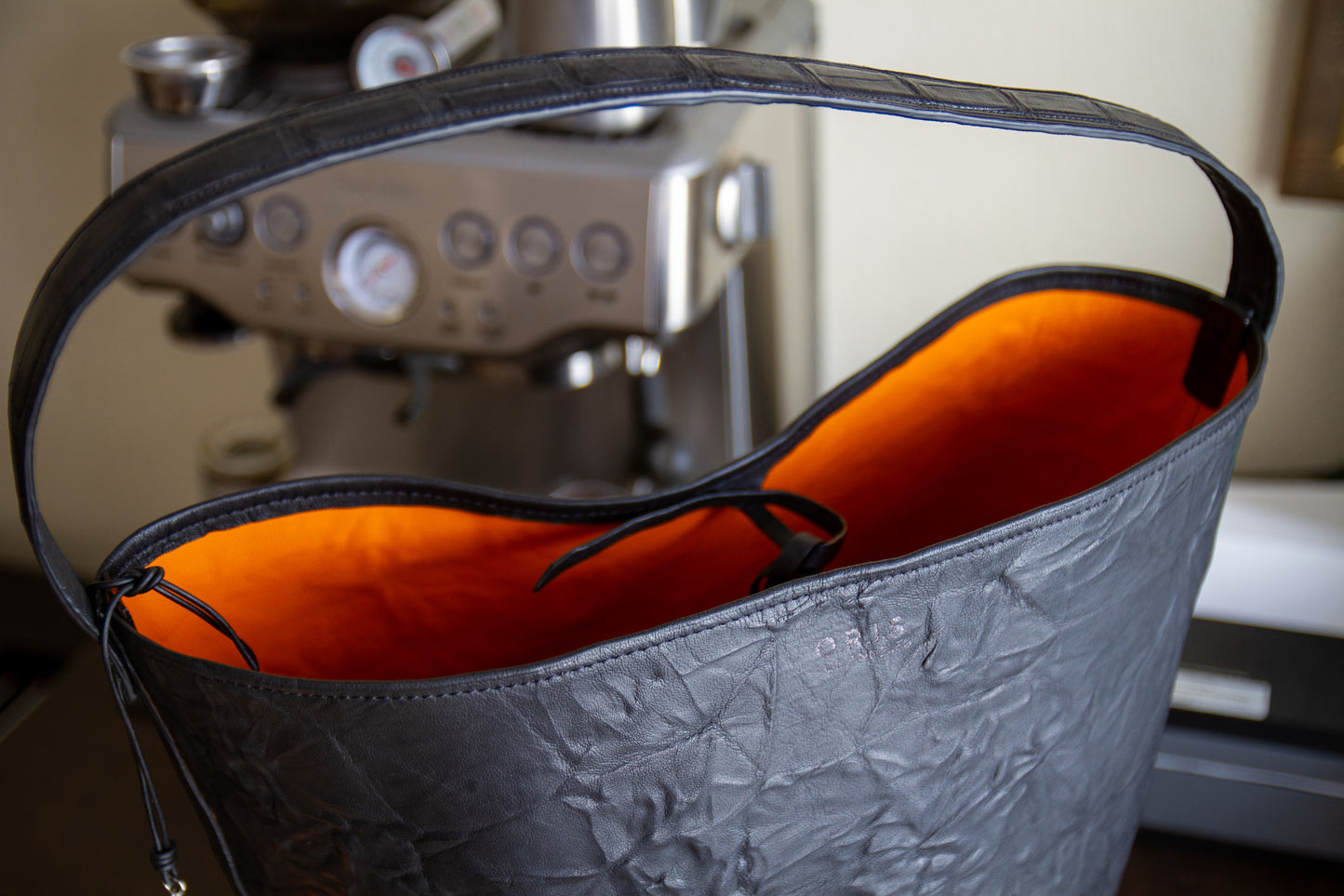 
                  
                    Top-down view into the custom leather tote showcasing the open interior lined with vibrant orange suede
                  
                