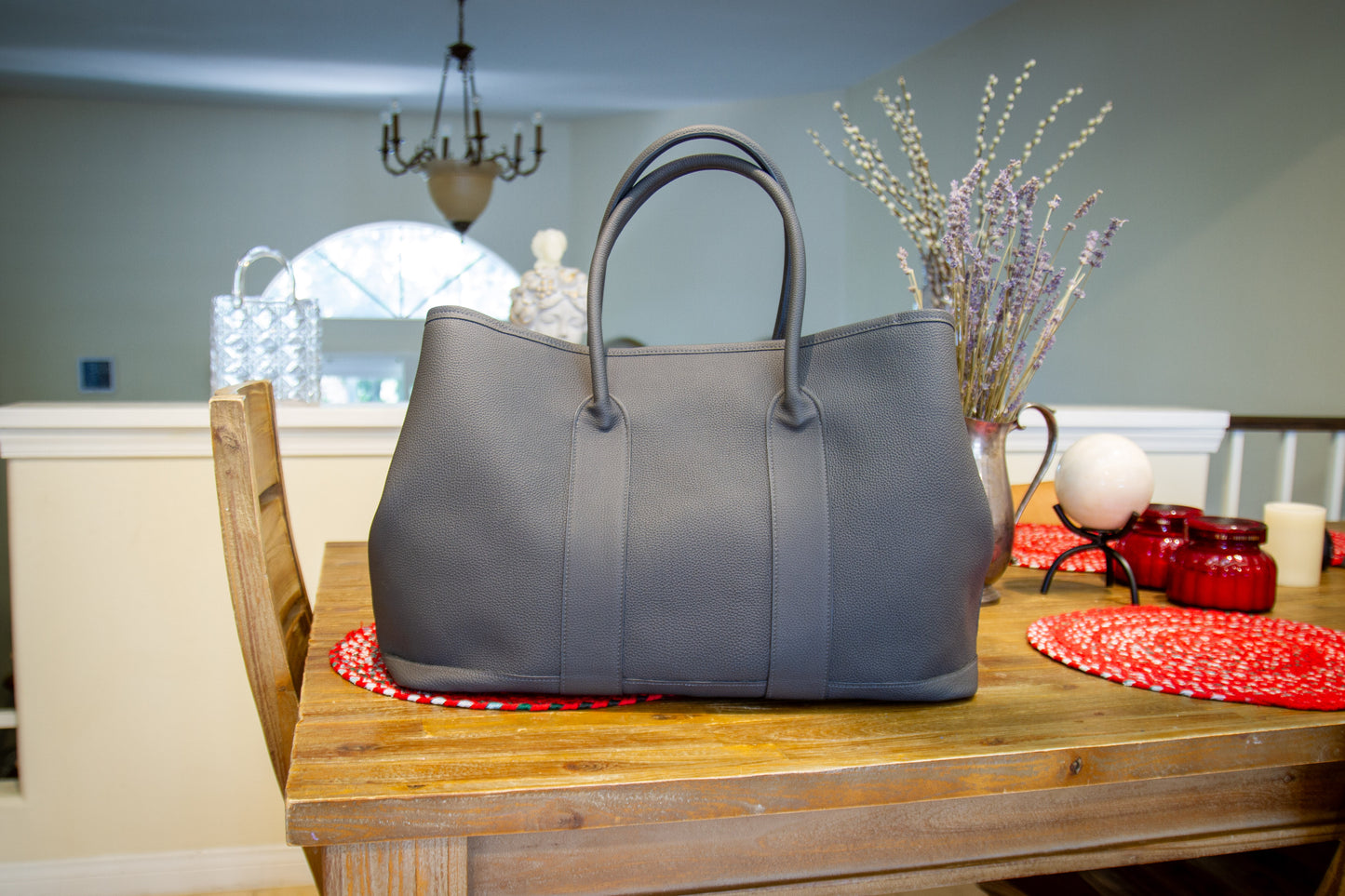 
                  
                    Custom gray leather voyager tote bag styled in a home interior setting
                  
                