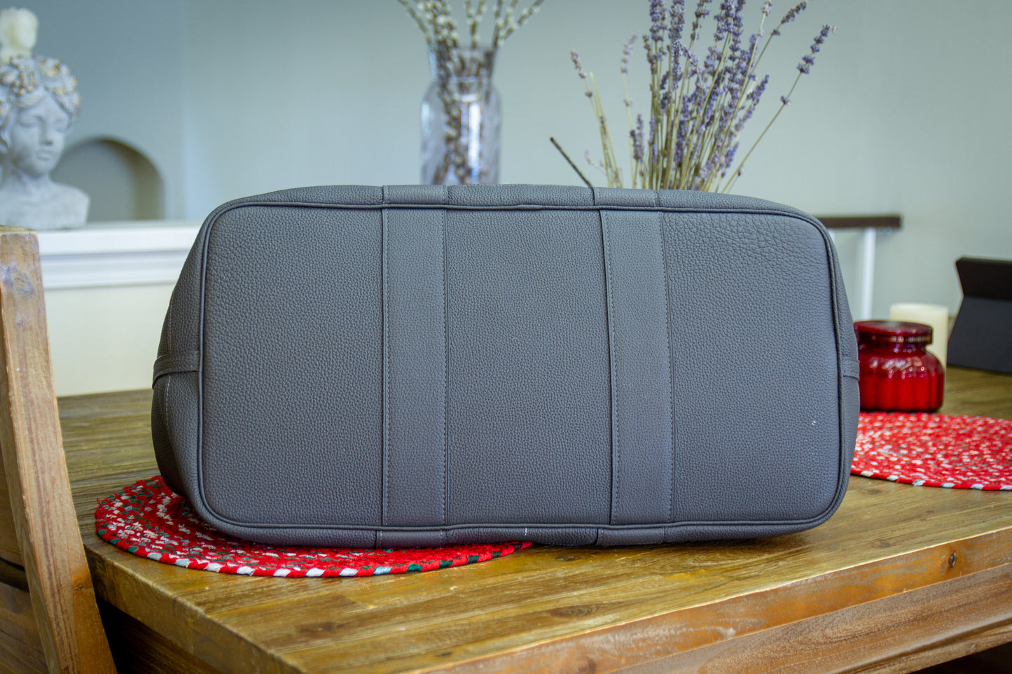 
                  
                    Flat bottom angle of a large gray pebbled leather travel bag showcasing bottom construction.
                  
                