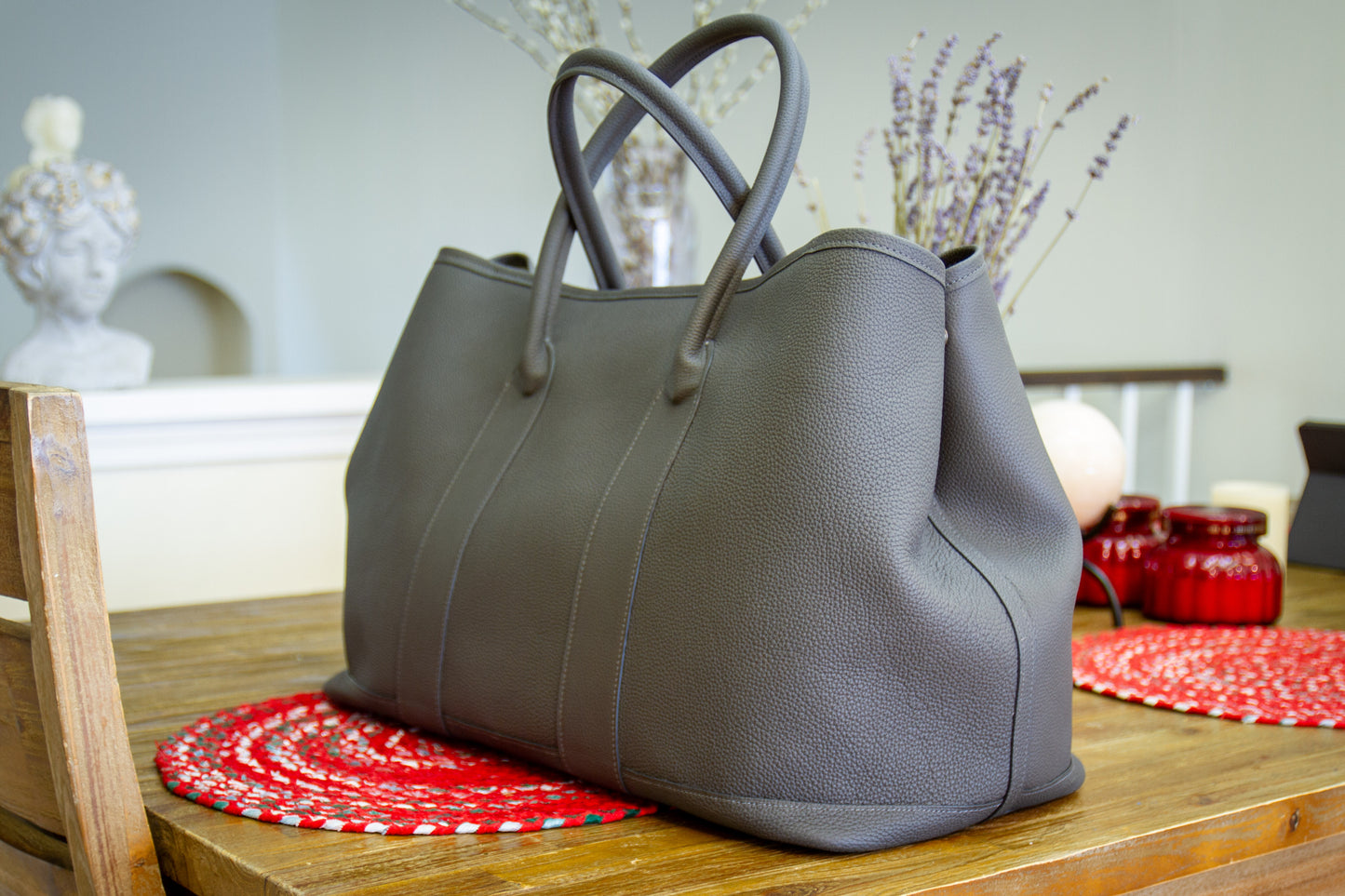 
                  
                    Side profile of a large bespoke gray leather weekender bag highlighting the reinforced base
                  
                