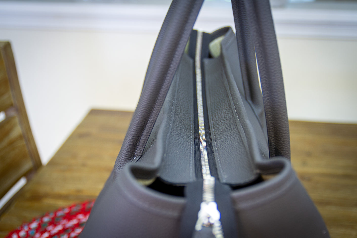 
                  
                    Top-down view into a large gray Togo leather tote showing the zipper closure
                  
                