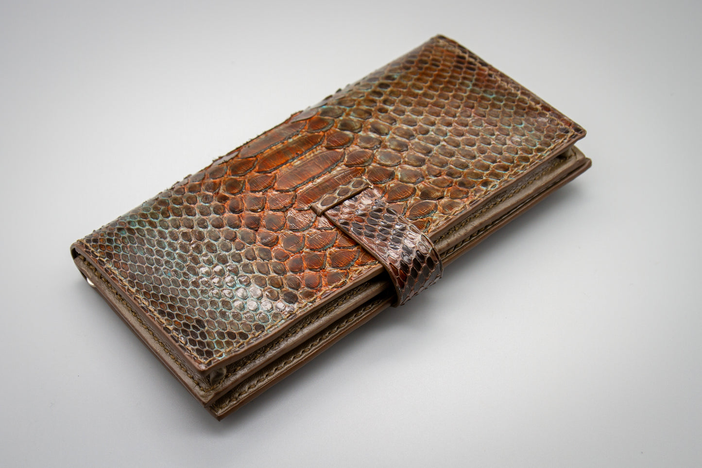 
                  
                    Rear view of a closed women's long wallet showing seamless hand-painted python leather pattern.
                  
                