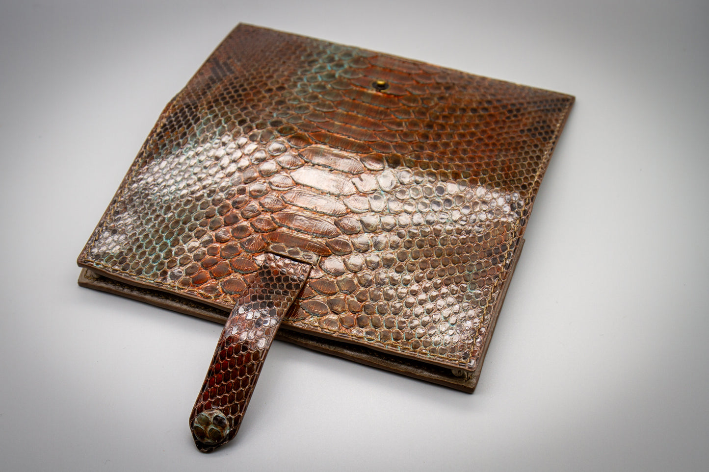 
                  
                    Open view of a women's long wallet from the back showing full exterior and closure strap
                  
                