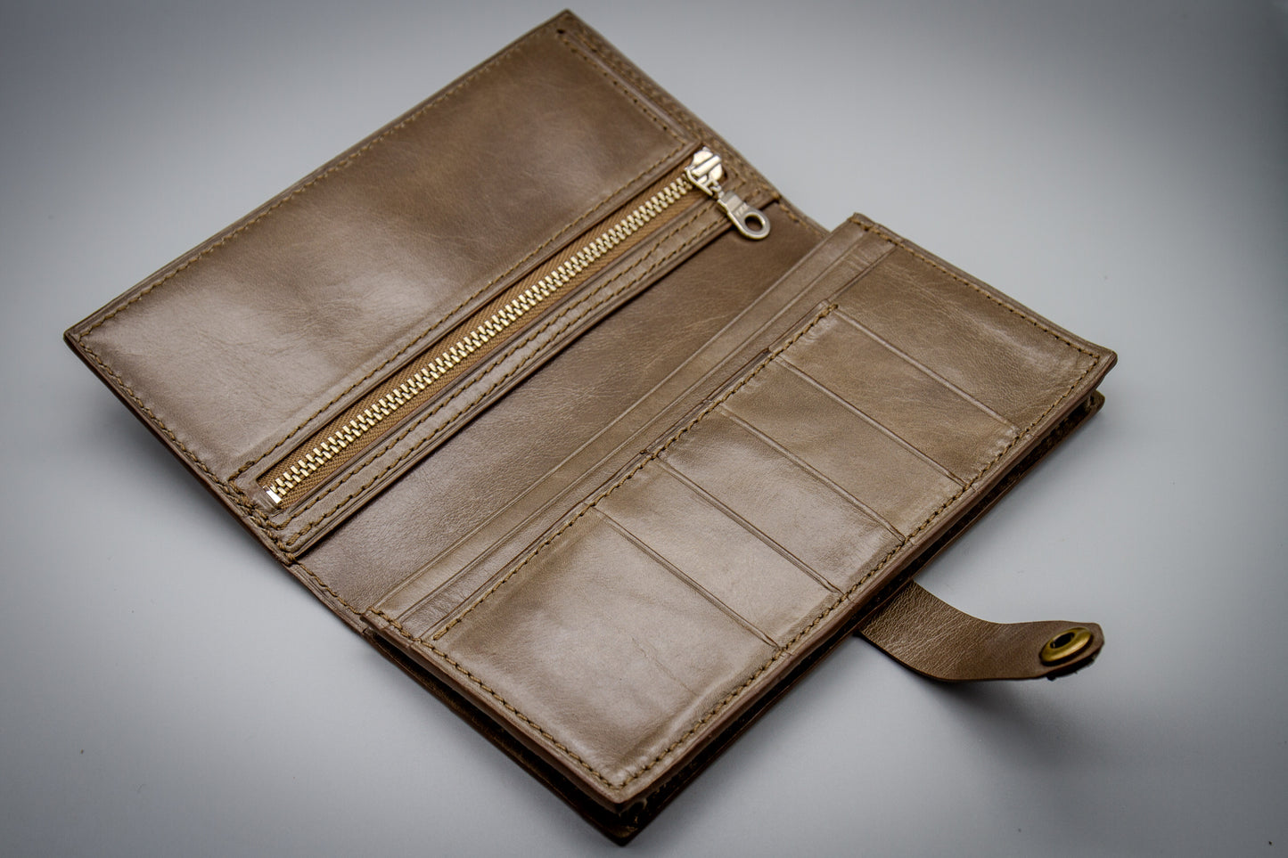 
                  
                    Open view of a women's long wallet showing full cowhide interior, card slots, cash compartments, and a YKK zipper pocket.
                  
                