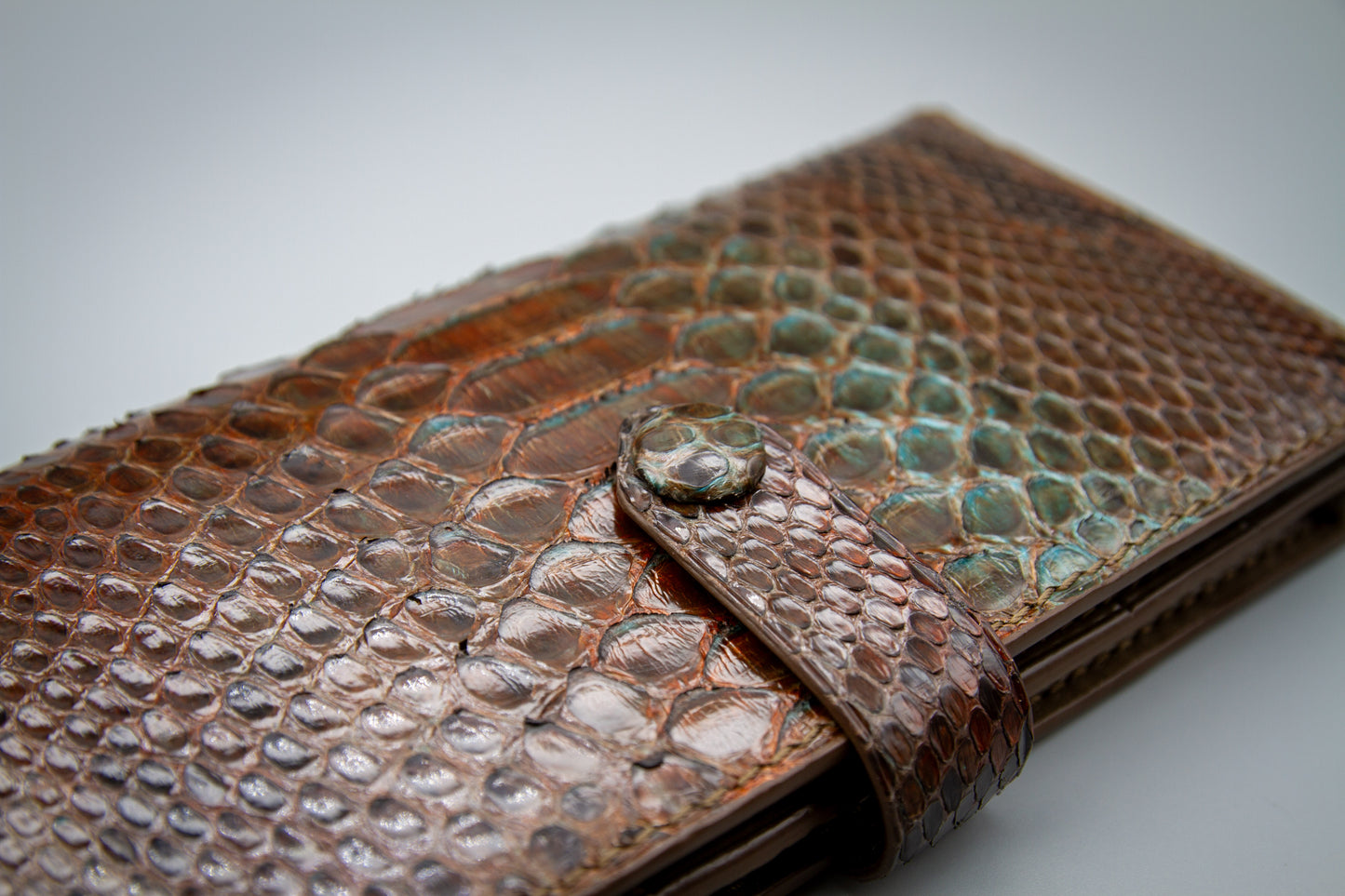 
                  
                    Another Macro shot of the covered brass snap button set on the hand painted python wallet's exterior
                  
                