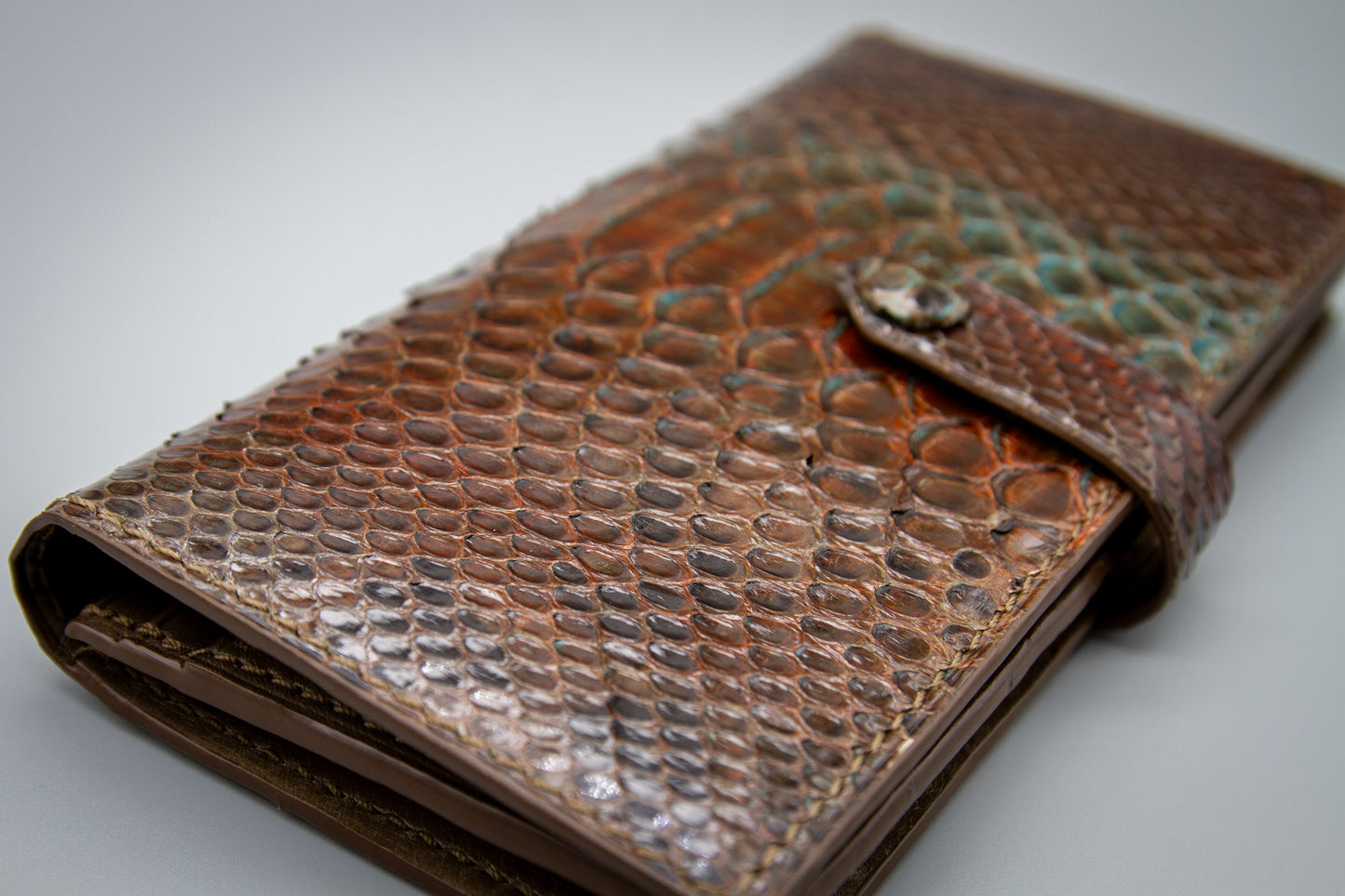
                  
                    Close-up detail showing the seam transition between the exterior python skin and inner cowhide edge.
                  
                