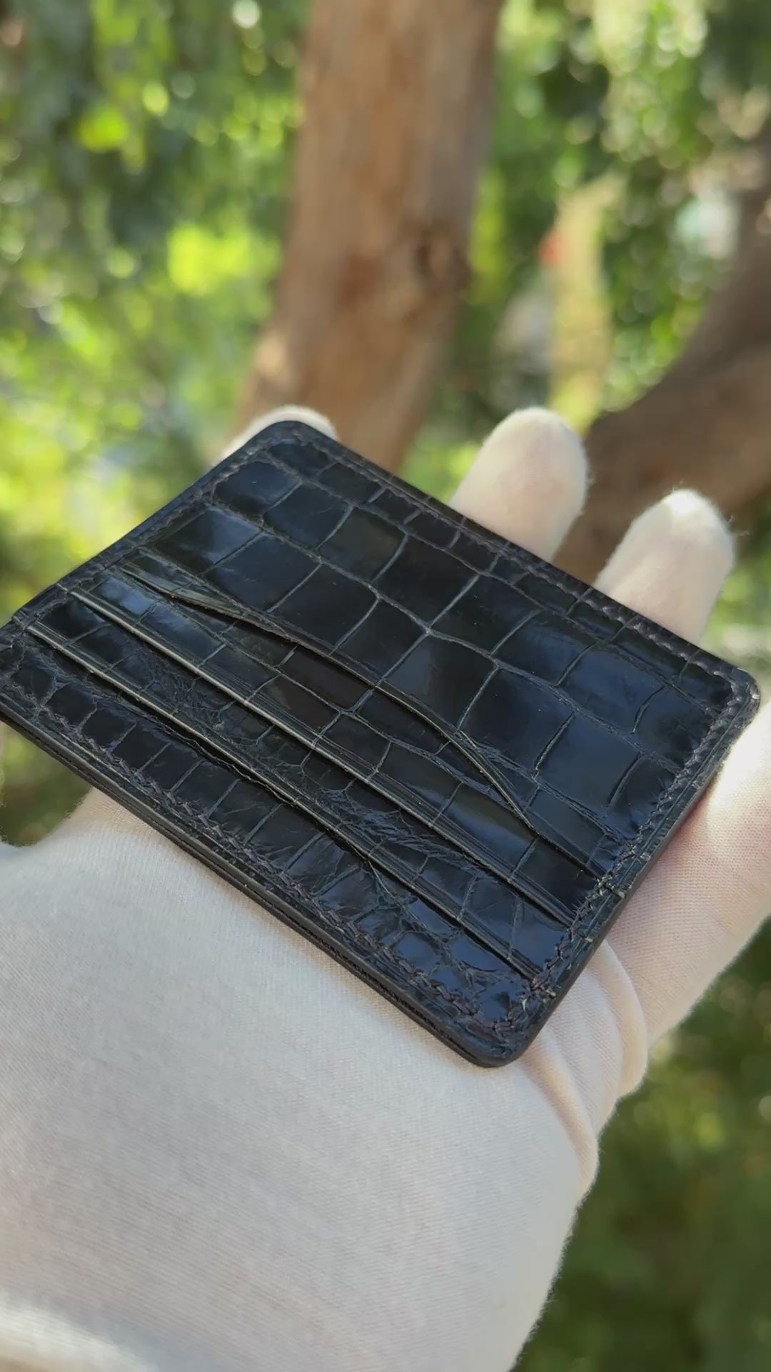 
                  
                    Load and play video in Gallery viewer, Video showing a 360-degree view and close-up craftsmanship details of a navy glazed alligator leather card holder.
                  
                